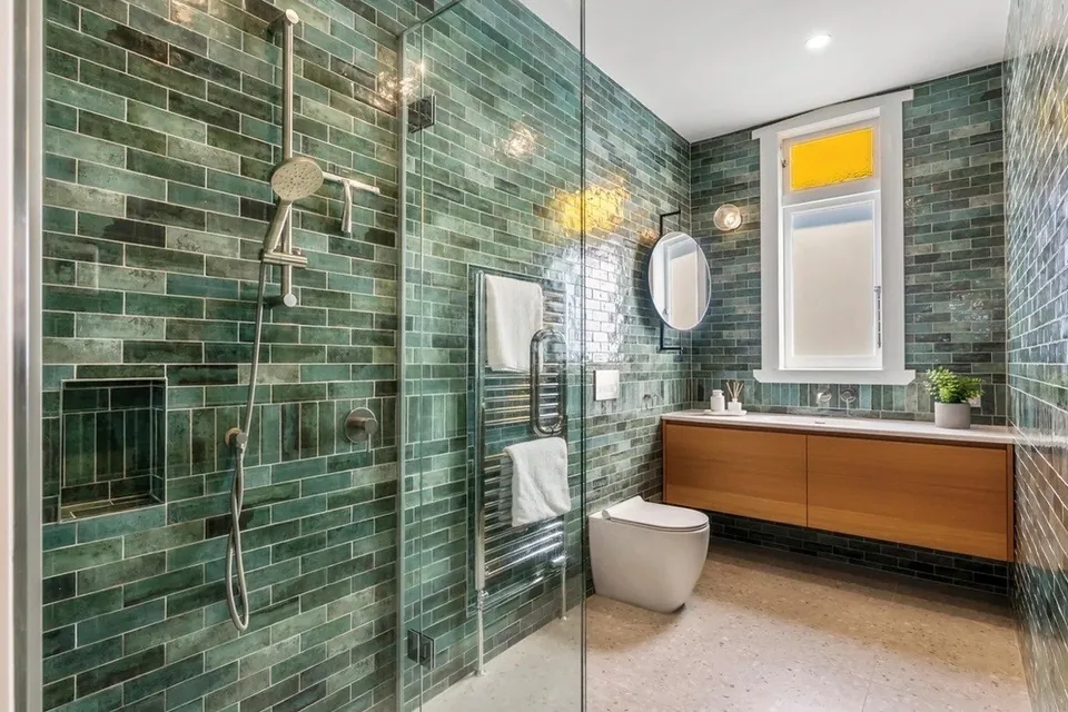 Completed bathroom renovation with tiled shower and vanity