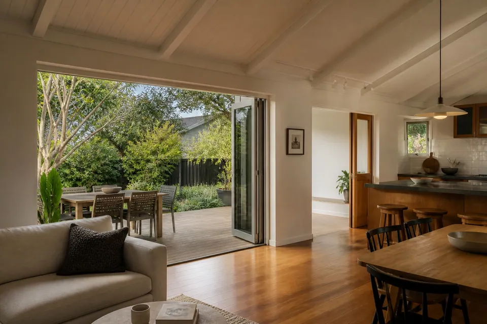 Auckland home interior opening to a timber deck and garden