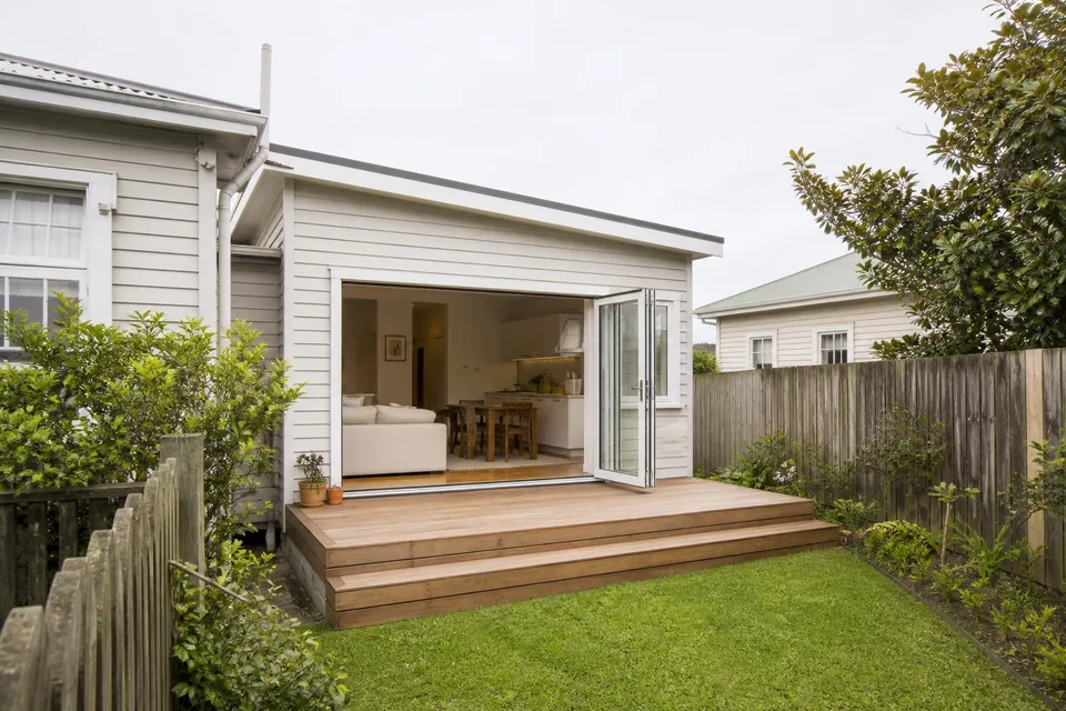Modest weatherboard home extension opening to a timber deck